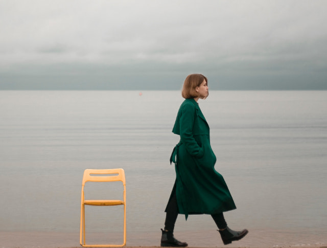 woman walks alone along beach
