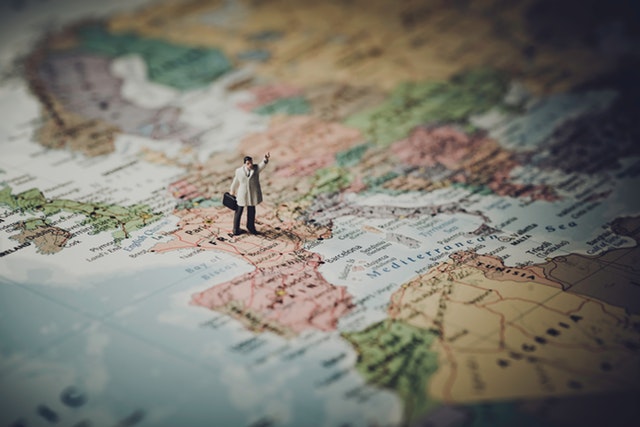 Small figure of man standing on a map