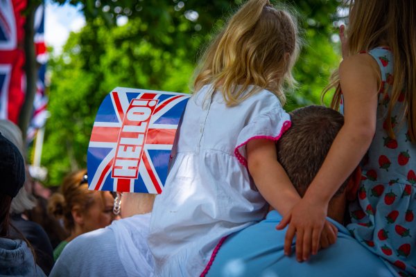 Child with British flag on fathers shoulders